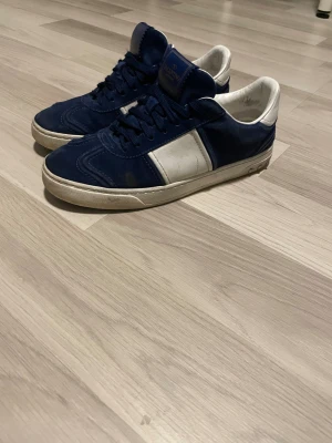 Valentino Rockrunner blå sneakers - Snygga Valentino Rockrunner sneakers i mörkblå mocka och vitt skinn. Klassisk låg modell med rund tå, snörning och vit platt sula. Perfekt för dig som gillar exklusiva streetwear-vibes och vill sticka ut med ett lyxigt märke. Kan ta emot byten👍Bra skick👌