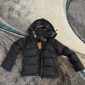 Svart burberry jacka  - Helt ny burberry jacka som är perfekt till vintern eller till en julklapp                                                        Den kan även bli till en väst (Skriv till mig om ni vill ha bild på västen).                                             Säljs på grund av att jag köpte fel storlek                       Storleken är S men den kan passa M                               Billigare vid snabbaffär 