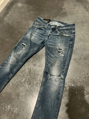 Blåa dondup jeans  - Dondup jeans med sjukt unika och snygga slitningar. Modellen är smal och sitter tight, inga färg stänk det är blekta fläckar !                                   Nypris 3500 mitt pris 1500 kr             Sitter inte så tight ni kan se själva på bilden .                                                     Modellen är 180cm och sitter perfekt ! | hör av dig vid minsta fundering !🤩