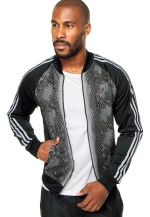 Adidas svart träningsjacka med mönster - Snygg Adidas Originals träningsjacka i mörkgrå/svart med unikt mönstrat framparti. Klassiska tre ränder längs ärmarna och dragkedja hela vägen framtill. Storlek 2XL  I riktigt fint skick – inga fläckar eller skador. Enda lilla anmärkningen är att det grå partiet runt kragen har börjat flagna/ljusna lite, men det syns inte vid användning.   Detta är ett plagg som är riktigt svårt att få tag på idag – perfekt för samlare och adidas-fans!