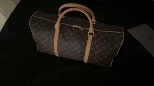 Louis Vuitton Keepall 50 - Klassisk Louis Vuitton resväska i brunt med ikoniskt monogrammönster och ljusbruna skinnhandtag. Väskan har dragkedja, medföljande axelrem och lås med nyckel. Perfekt storlek för weekendresor och har exklusiva detaljer från Paris. Dm för mer bilder✨