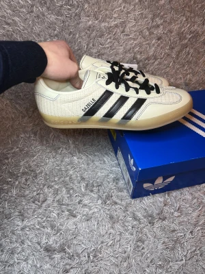 Adidas Gazelle indoor - Säljer ett par sköna Adidas Gazelle Indoor som tyvärr inte passa mig! | Nya aldriga använda! Beige/vit aktig färg finns även vita snören till! | Storlek 41 1/3 skickar gärna mått! | Ställ gärna frågor innan du köper!