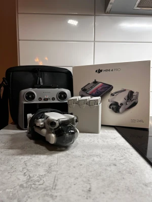 DJI Mini 4 Pro combo  - DJI Mini 4 Pro drönare med fjärrkontroll, tre batterier, väska och originalkartong. Ultra-lätt modell (under 249g) med avancerad kamera och smarta flygfunktioner. Utrustningen ser ut att vara i mycket gott skick utan synligt slitage.