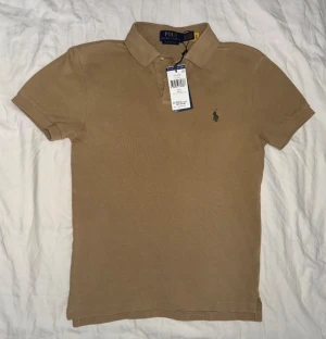 Beige pikétröja från Ralph Lauren - Polo Ralph Lauren khaki pikétröja  Storlek: xs Nypris: 1400kr Oanvänd!