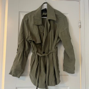 Grön trenchcoat - Säljer denna trenchcoaten som går man kan styla hur man vill💗💗 I jackan står det att storleken är xs/s och jag skulle säga att det stämmer bra