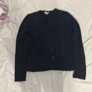 Mörkblå kofta från Gina Tricot - Mysig mörkblå kofta från Gina Tricot i storlek 158/164. Koftan har rund halsringning, långa ärmar och knäppning med svarta knappar framtill. Perfekt för lager-på-lager och enkel att matcha med olika outfits. Är bara använd 2 ggr och är i mycket bra skick, har inga defekter är som helt en helt ny💗