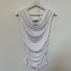 ”Shoulder” top från Meet Me There - Vit ”Shoulder” top från Meet Me There i storlek XXS/XS. Helt oanvänd med prislapp kvar. Nypris 40 euro