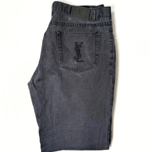 Yves Saint Laurent Jeans - Vintage Saint Laurent jeans med snygg klassiska YSL loggan på bakfickan. Ingen sizetag, mått - Längd 99 cm, midja 45 cm, benöppning 22,5 cm. Retail idag: ~8,000 SEK.