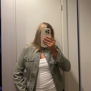 Grön jeansjacka med knappar - Snygg ljusgrön jeansjacka med klassisk passform och knappar framtill. Jackan har två bröstfickor med lock och knapp, samt långa ärmar med knapp vid ärmslut. Perfekt att slänga över en t-shirt🧸