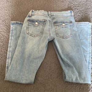 Ljusblå bootcut jeans Gina Tricot - Säljer ett par ljusblå bootcut jeans från Gina Tricot i storlek 170. Jeansen har slitna detaljer vid knäna, klassiska bakfickor med lock och knapp samt röda sömmar. Perfekta för dig som gillar en avslappnad och trendig look. Använd Cirka 2 gånger☺️