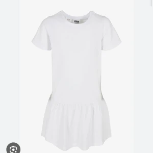 Vit kort klänning  - Enkel och fräsch vit kortklänning med rund halsringning och korta ärmar. Klänningen har en avslappnad passform och lätt rynkad kjol, perfekt för en chill och stilren look. Tillverkad i mjuk bomull för maximal komfort.