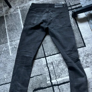 Svarta slim jeans från Tiger of Sweden - Tecken på användning annars jättebra, skriv vid funderingar. 30/32