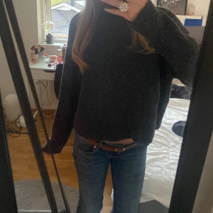 Mörkgrå stickad polotröja - Mysig mörkgrå stickad polotröja med lång ärm och relaxed fit. Tröjan har en hög krage och är lite croppad i modellen, perfekt för lager på lager. Passar dig som gillar en enkel men stilren look. Från Kappahl 