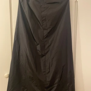 Svart lång kjol från InWear - Elegant svart lång kjol från InWear i en stilren och enkel design. Tillverkad i en blandning av nylon och polyester med foder i acetat. Perfekt för dig som gillar minimalistisk och tidlös stil. Stl:EUR 40