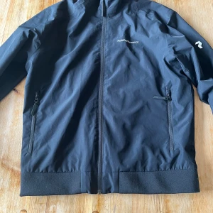 Peak performance jacka - Svart vindjacka som även tål lätt regn, perfekt höstjacka. Nypris ca 2000 kr. Knappt använd. Finns en liten skada på högarmen men inget som syns, se 3e bilden