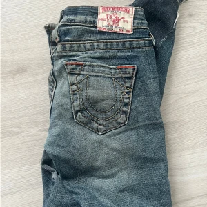 True Religion blå jeans med broderade fickor bootcut - Snygga blå jeans från True Religion med ikoniska broderade bakfickor. XS 32 väldigt lågmidjade bootcut säljer för passar inte riktigt mig längre😊. priset går att diskutera 