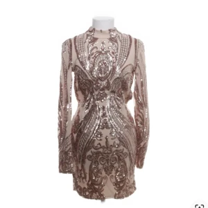 Glittrig kortklänning från Tiger Mist - Superfin glittrig kortklänning från Tiger Mist i champagnefärg med paljettmönster. Klänningen har lång ärm, hög hals och en öppen rygg som ger en extra wow-effekt. Materialet är 95% polyester och 5% spandex för en tight och bekväm passform.