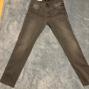Gråa Replay Jeans Anbass - Ett par snygga Replay Jeans i grå färg. Modell: Anbass, Hyperflex  • Size 31 • Längd 98cm • Innerbenslängd 74cm • midjemått 37cm