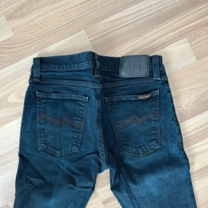 Mörkblå nudie jeans - Ett par mörkblå nudie jeans i perfekt skick utan defekter. Den är i modellen long John och säljs då den inte används så mycket. Storlek W29/L30