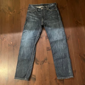 Mörkblå jeansbyxor från Weekday - Snygga mörkblå jeansbyxor från Weekday med klassisk femficksdesign och kontrastsömmar. Jeansen har rak passform och normal midja, tillverkade i slitstarkt denimtyg. Perfekta för dig som gillar en tidlös och clean look. Modell: Klean. Storlek 31W 32L. Använd två gånger. 