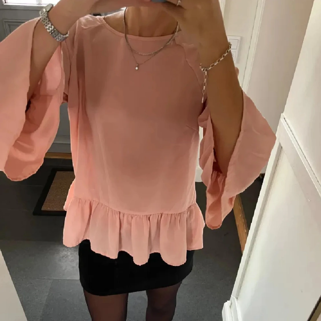 Ljusrosa volangblus med vida ärmar