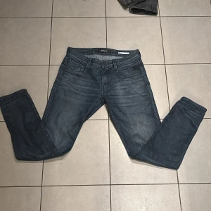 Replay Anbass jeans i mörkblå denim - Snygga Replay Anbass jeans i mörkblå tvätt med klassisk femficksdesign. Jeansen har smal passform och raka ben, tillverkade i mjuk och stretchig bomullsdenim. Perfekta för dig som gillar en stilren och modern look. Nästan alldrig använt 