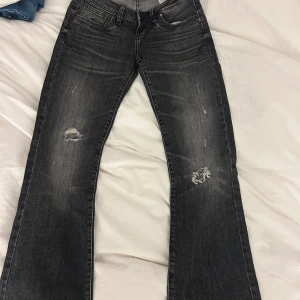 Svarta bootcut jeans från LTB  - Snygga svarta jeans från LTB med bootcut passform. Jeansen har slitna detaljer på benen och klassisk femficksdesign. Materialet är jeans och färgen är mörkgråsvart med tvättad look. Perfekta för dig som gillar en avslappnad men trendig stil.