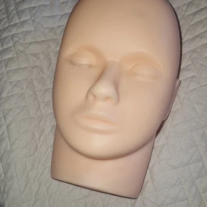 Träningshuvud - Träningshuvud i mjukt silikonmaterial – perfekt för att öva på fransförlängning, sminkning, ansiktsmålning eller andra skönhetsbehandlingar. Kan användas flera gånger och är lätt att rengöra. Det finns några ytterst små fläckar under ena ögat som jag inte riktigt provat att få bort, annars i mycket fint skick.