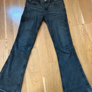 Svarta bootcut jeans från Gina Tricot - Snygga svarta bootcut jeans från Gina Tricot med råa, fransiga benslut. Jeansen har klassisk femficksdesign och normal passform. Använda men i bra skick.     Storlek 146