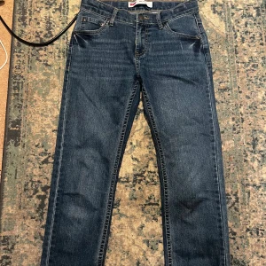 Levi's 511 Slim jeans mörkblå - Snygga Levi's 511 Slim jeans i mörkblå tvätt med klassiska fem fickor och gul kontrastsöm. Modellen har rak passform med smal siluett och normal midja. Perfekt för dig som gillar stilrena och tidlösa jeans med en modern touch.