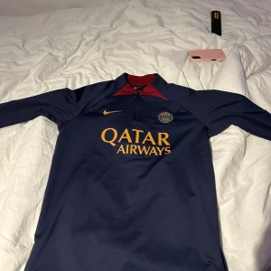 Psg tracksuit - Säljer en mörkblå Psg tracksuit som är storlek L på tröjan och Xl på på byxor. Den är dock slim fit så passar vid en storlek mindre på båda också. Pris är 500 för bara tröjan, 400 för bara byxor. Om ni vill ha hela setet så kan ni få den för 700-800 pris går alltid att diskutera. Notera även  att den har en liten fläck från konstgräs på vänster knä så priset är absolut inte fast