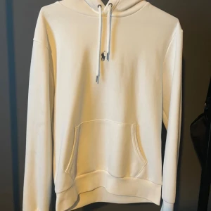 Vit hoodie från Polo Ralph Lauren - Säljer en stilren vit hoodie från Polo Ralph Lauren med klassisk broderad logga på bröstet. Tröjan är nästan helt oanvänd. Vänlig och kontakta om du har fler frågor.