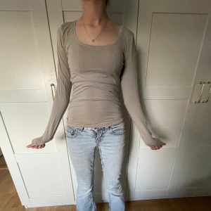 Beige långärmad topp från H&M - Slimmad beige långärmad topp från H&M med rundad halsringning. Tunn och mjuk känsla, perfekt att styla med jeans eller kjol. Enkel design som är lätt att matcha med andra plagg. Storlek S.
