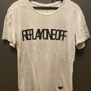 Vit t-shirt Replay One Off - Vit t-shirt från Replay One Off med stor svart print på bröstet. Klassisk rund hals och korta ärmar. Mjuk och skön i bomull, perfekt för en chill och stilren look. Diskret Replay-märke nedtill på framsidan.