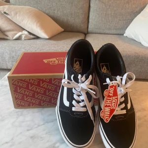 Svarta Vans Sneakers Mocka 38.5 - Klassiska Vans Sneakers i svart mocka med vit sula. Perfekt skick. Helt nya. Kommer med originalkartong och tagg.