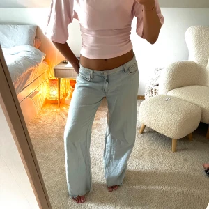 Ljusblå wide jeans från bikbok  - Säljer ett par ljusblå jeans från bikbok med loose fit och wide ben. Byxorna har låg midja, klassiska fem fickor och råa kanter nertill för en avslappnad vibe. Perfekta för dig som gillar en chill och trendig look.