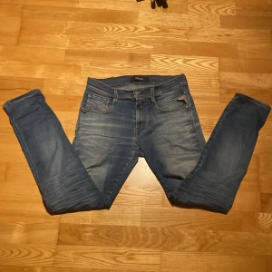 Replay anbass hyperflex - Säljer ett par blå jeans från Replay i slim fit-modell. Jeansen har klassisk femficksdesign, snygga slitningar och en något tvättad look. Materialet är stretchigt jeans för skön passform. Perfekta för dig som gillar en smalare siluet