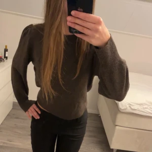 Brun stickad tröja med puffärm - Mysig brun stickad tröja med puffiga ärmar och rund hals. Stilren och enkel att matcha med olika outfits. 