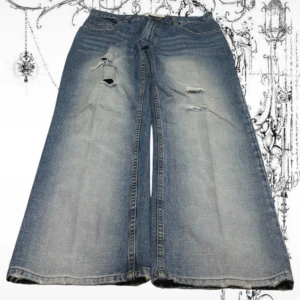  jeans med slitningar, blå, S - Vida bootcut jeans i ljusblå denim med slitna detaljer och hål på framsidan. Jeansen har klassisk femficksdesign och markerad tvätt för en cool vintagekänsla. Perfekta för dig som gillar en avslappnad och trendig look.