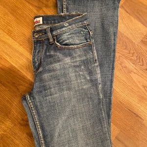 Bootcut jeans från Colours of the World - Snygga vintage blå bootcut jeans från Colours of the World i klassisk tvättad denim. Byxorna är lågmidjade, och har slitna detaljer på bakfickorna. Passar någon som är mellan 165-170 cm🫶 Skriv för bild på