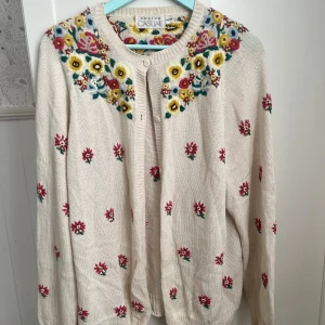 Blommig kofta från Gulins Casual - Superfin beige kofta från Gulins Casual med broderade blommor. Koftan är stickad i storlek 42 vilket ger en oversize look. 
