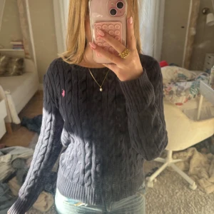 Mörkblå stickad tröja från Polo Ralph Lauren - Snygg mörkblå stickad tröja från Polo Ralph Lauren med rosa märke. Inte använd alls mycket. Storlek L på barnstorlek men passar bra som xs/s