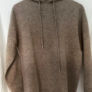 Brun-beige Kashmir hoodie - Säljer en riktigt fet brun kashmir/merinoull hoodie i storleken S. Den är i nyskick. Tröjan är i toppkvalite och är kashmir och merinoull blandning. Skriv om du har några funderingar (mått, passform, pris, bilder). Mvh KC Closet.