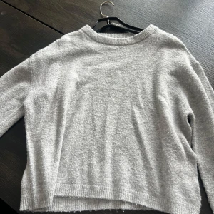 Ljusgrå stickad tröja från 157 - Mysig ljusgrå stickad tröja från 157 med rund halsringning och ribbade muddar. Perfekt för lager-på-lager och chill dagar. Enkel och stilren design som funkar till det mesta.