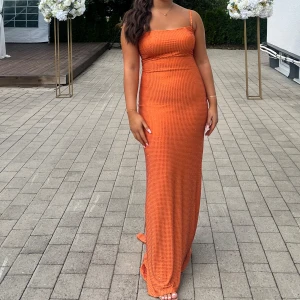 Orange långklänning med smala axelband - Säljer en orange långklänning med smala axelband och figurnära passform. Den har endast använts i några timmar. 