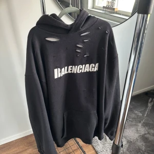 Svart hoodie från Balenciaga Unifit Caps destroyed - Svart oversized Caps Destroyed modell hoodie från Balenciaga med vit logga framtill. Storlek XL nyskick.