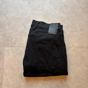 Replay anbass hyperflex - Schyssta jeans med en fin ton av svart från Replay. Skick 9/10 Jeansen är endast använda ett fåtal gånger | Model: anbass hyperflex | Storlek: W30 l32 | Nypris ligger på 1699kr | Det är bara att skriva om ni har frågor eller funderingar!
