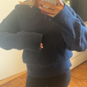 Mörkblå stickad hoodie - Mysig mörkblå hoodie medoch luva. Tröjan är fluffig och har långa ärmar med breda muddar. Pris kan diskuteras 