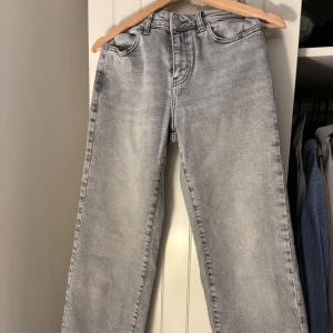 Gråa jeans från Noisy May - Snygga grå jeans från Noisy May med stentvättad look. Modellen har klassisk femficksdesign, midwaist och vida ben. Jeansen är tillverkade i bomull och har en cool, ljusgrå tvätt som ger en trendig vibe.