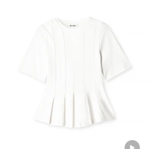 Vit blus med veck från NA-KD - Säljer en vit blus från NA-KD med rund halsringning och korta ärmar. Toppen har snygga vertikala sömmar och veck nertill som ger en peplum-effekt. Tillverkad i mjuk bomull, perfekt för en clean och fräsch look. Max använd 2 gånger 🩷